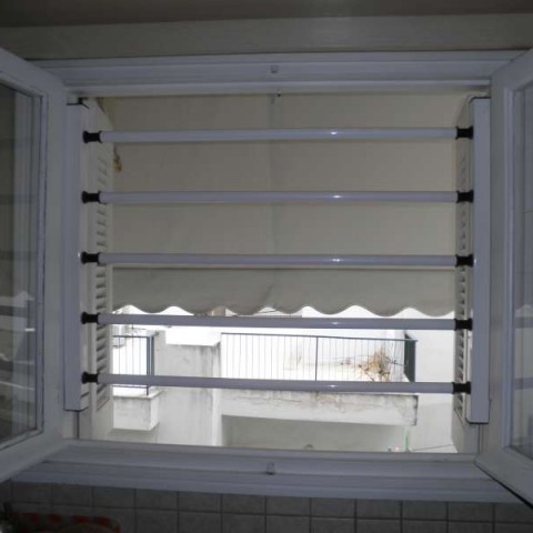 Fixed security bars outside a glass pane that opens