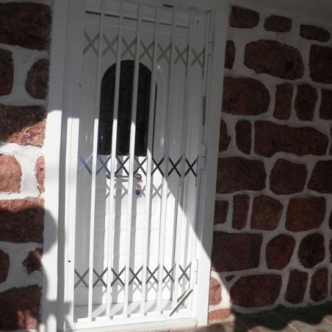 Retractable security gate for a door to a holiday home